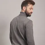 Polera color beige de tejido de punto con cuello alto.