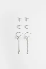 Set de tres pares de aros plateados con apliques de vidrio transparente, que incluye un par de pequeños pendientes tipo botón con forma geométrica, un par de aros pequeños con incrustaciones y un par de aros colgantes decorados con dijes en forma de estrella y cadenas colgantes con cuentas.