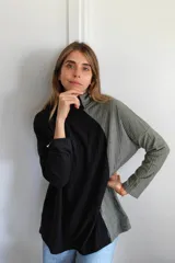Polerón de cuello alto con diseño bicolor en negro y verde oliva. Confeccionado en tejido de punto acanalado, presenta un corte holgado y asimétrico con mangas largas.