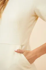 Vestido marrón de lana fina, corte a la rodilla, con mangas cortas y bolsillos laterales.