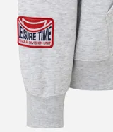 Buzo tipo hoodie con corte boxy, confeccionado en algodón con fondo melange. Presenta capucha, bolsillo canguro frontal, puños y ruedo acanalados, y múltiples parches bordados decorativos en el frente y las mangas.