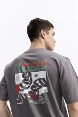 Remera de manga corta color celeste claro, con cuello redondo y estampado gráfico grande en la espalda con la palabra "BLESSED" y frases como "BE GRATEFUL EVERY MOMENT". Incluye el logo de la marca Mistral.