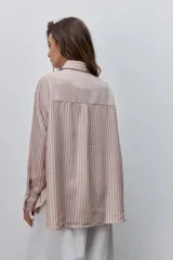 Camisa de manga larga con diseño de rayas verticales blancas y verdes, calce relajado, cuello clásico y botonadura frontal con botones perlados.