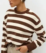 Suéter de cuello redondo confeccionado en tejido de chenille con diseño de rayas horizontales. Presenta mangas largas con puños acanalados y bajo ajustado, ofreciendo una textura suave y aterciopelada.