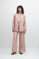 Blazer oversize de lino color rosa metalizado, con solapas de muesca, cierre con doble botonadura y bolsillos delanteros con solapa.