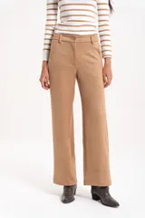 Pantalón de corte recto y tiro alto, confeccionado en material símil gamuza con textura suave.