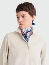 Pañuelo cuadrado de seda con estampado vibrante que incluye motivos de la Torre Eiffel, flores y elementos decorativos en tonos azul marino, blanco, naranja y rojo.