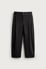 Pantalón de corte balloon fit confeccionado en tejido con viscosa. Presenta cintura ajustable con cinturón integrado, pliegues frontales, bolsillos laterales y bolsillos traseros de doble vivo. Cierre frontal con cremallera y botón.