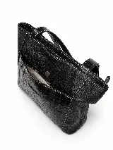 Cartera tipo tote de cuero vacuno marrón, con doble asa larga de hombro y cierre superior. Presenta un bolsillo frontal externo con textura símil cocodrilo y detalles de costuras visibles.