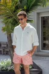 Camisa blanca de manga larga con cuello clásico y botones frontales.