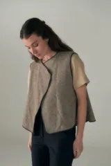 Chaleco corto de lana fina sin teñir, con diseño de solapa cruzada y terminaciones envivadas. Es una prenda reversible, liviana y versátil, ideal para uso diario.