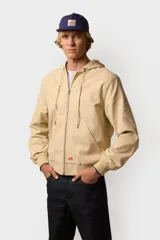 Campera color beige con capucha, cierre frontal con cremallera, bolsillos laterales y puños elásticos.