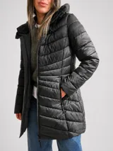 Campera puffer negra con capucha, diseño acolchado, cierre frontal y bolsillos laterales. Presenta un corte entallado y largo a la cadera.