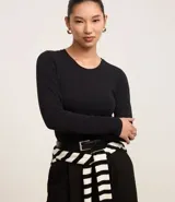 Blusa de algodón color negro, de corte ajustado, con cuello redondo y mangas largas.