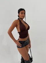 Top negro con escote profundo en V y cuello halter, estilo cruzado en la espalda.