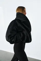 Chaqueta bomber negra ZW Collection con acolchado interior, cuello envolvente de solapa cruzada, mangas largas con puños elásticos y bajo con elástico.