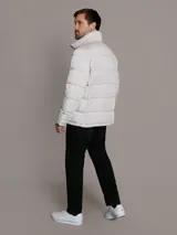 Campera puffer Calvin Klein acolchada, de color gris claro, con cuello alto, cierre frontal con cremallera negra y bolsillos laterales con cierre.