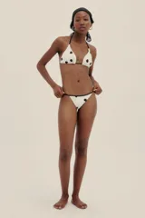 Bottom de bikini color crema con estampado de lunares negros y tiras finas regulables.