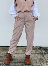 Pantalón de vestir color beige, con pinzas, bolsillos laterales y cierre frontal.