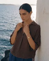 Blusa de lino color blanco, con cuello camisero y escote en V profundo, mangas 3/4 y corte holgado.