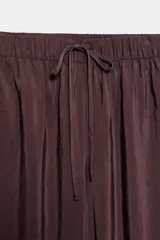 Pantalón fluido confeccionado en mezcla de modal, de tiro medio con cintura elástica ajustable con cordón y bolsillos laterales, en color tostado.