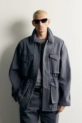 Parka relaxed fit de algodón color gris con efecto lavado. Cuenta con cuello solapa, cuatro bolsillos de plastrón con solapa en el frente y cierre frontal con cremallera oculta por solapa con botones a presión.
