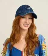 Gorra de sarga de algodón color azul denim, con visera curva y cierre ajustable con hebilla. Presenta bordado en blanco en la parte frontal con el texto "RIO DE JANEIRO BRASIL".