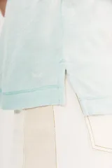 Remera de manga corta con escote pronunciado en V, calce relajado y suave al tacto. Presenta un ligero efecto tie-dye o desteñido en tonos celestes y blancos.