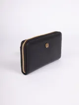 Billetera negra de símil cuero con cierre perimetral. Tiene dos compartimentos, espacio para ocho tarjetas, efectivo y un bolsillo con cierre para monedas.