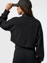 Canguro negro con cremallera, confeccionado en tejido con tecnología Aloe Vera, cuello alto y mangas largas con puños ajustados. Presenta un diseño corto con chaleco incorporado elástico y ajustable en la cintura.