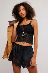 Musculosa corta y semitransparente de encaje floral negro, con tirantes ajustables.