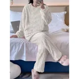 Pijama de dos piezas de tejido plush texturado con diseño de puntos en relieve, compuesto por un buzo de manga larga con cuello redondo y un pantalón largo de corte recto.