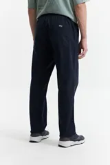 Pantalón de gabardina color azul marino, con diseño de cinco bolsillos, corte relajado, cintura elastizada con cordones ajustables y terminación recta sin puños.