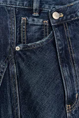 Falda midi de denim azul con tiro medio, diseño asimétrico de bajo cruzado y cinco bolsillos clásicos.