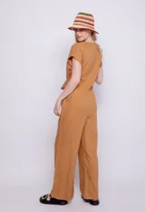 Mono color verde oliva de lino y viscosa, con botones veteados, manga corta, dos bolsillos laterales y lazo para atar a la cintura.