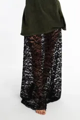 Pollera larga de encaje negro con diseño floral y volado en el ruedo.