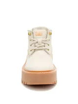 Bota tipo chukka de Caterpillar, color beige, con plataforma alta y suela dentada de goma color caramelo. Presenta cordones al tono, ojales metálicos dorados y logo de la marca grabado en el lateral y la lengüeta.