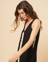 Vestido largo blanco de lino con escote en V y flecos de algodón en los bordes.