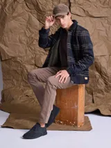 Chaqueta de lana con cierre frontal completo, diseño a cuadros en tonos azul marino y verde, cuello camisero y bolsillos laterales.