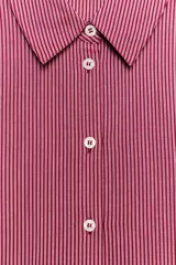 Camisa de manga larga con cuello solapa, cierre frontal con botones y bajo asimétrico, con estampado de rayas verticales.