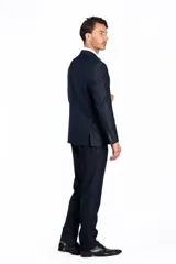 Traje de dos piezas color azul marino, compuesto por chaqueta estructurada con solapas clásicas y pantalón de vestir a medida. Diseño formal de corte impecable.