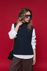 Chaleco de punto liviano color azul marino, con cuello alto y diseño sin mangas de silueta relajada.