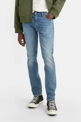 Jean de corte slim taper en color azul medio, de tiro medio con diseño de cinco bolsillos y efecto ligeramente deslavado.