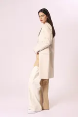 Blazer largo color beige, de corte recto y solapas clásicas.