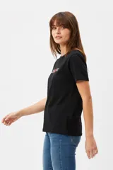 Remera blanca de manga corta y cuello redondo, con corte holgado y estampado frontal que dice 'I <3 LA' con letras de animal print y un corazón rojo.