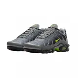 Championes Nike Air Max Plus de diseño técnico, color gris con detalles en verde neón en el logo lateral y en las unidades de aire de la suela. Presentan una estructura de malla transpirable con refuerzos sintéticos ondulados.