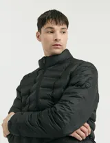 Campera capitoneada de poliéster con cierre frontal al tono y bolsillos laterales con cierre invisible.