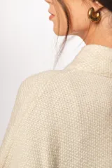 Capa cruda de lana merino uruguaya, con botones de madera y cuello adaptable.