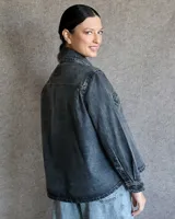 Sobrecamisa de denim azul con cuello camisero, cierre frontal con botones, mangas largas con puños abotonados y dos bolsillos con solapa en el pecho.