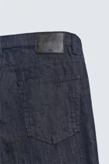 Jeans de corte slim fit en color azul oscuro, con diseño de cinco bolsillos, cierre frontal con cremallera y botón, y tejido ligeramente elástico.